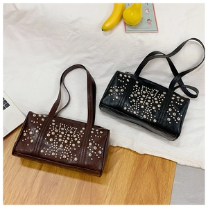 Close-up of punk style rivet shoulder bags in brown and black with silver metal studs