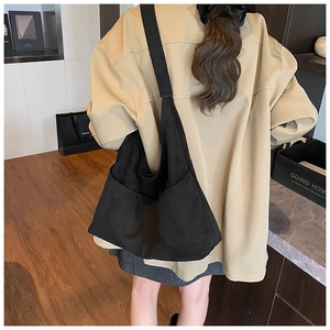 Borsa hobo nera opaca di grandi dimensioni abbinata a una giacca beige casual