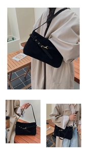 Detail of matte suede shoulder bag with decorative belt buckle and gold metal accents