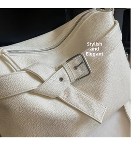 Detailed close-up of white lychee pattern leather texture and silver buckle hardware