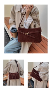 Detail view of a vintage dark brown matte suede shoulder bag with belt buckle straps
