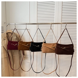 Detailed display of five colorful vintage suede shoulder bags hanging on a rack