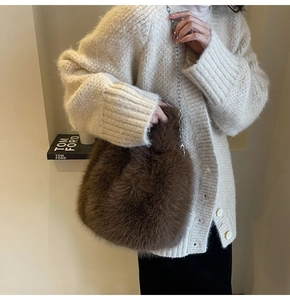 Détail du sac en peluche marron foncé avec chaîne argentée et texture douce en fausse fourrure