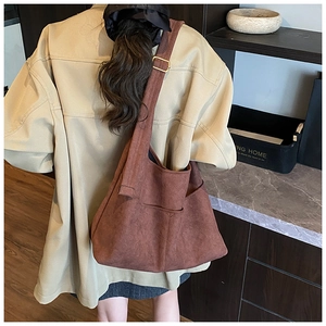 Dettaglio della borsa hobo in pelle scamosciata marrone scuro con tracolla regolabile
