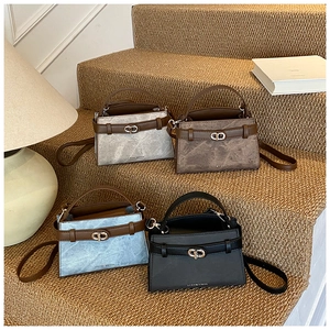 Detailed close-up of trapezoid leather buckets bags in grey, brown, blue and black colors