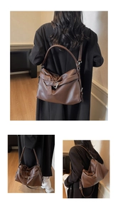 Detail of dark brown litchi pattern hobo bag with horizontal strap and metal buckle