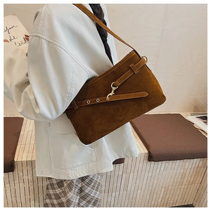 Detail of caramel brown matte suede shoulder bag with unique brass hook hardware