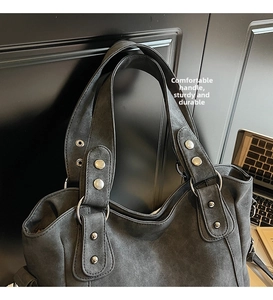 Detail of comfortable matte leather handle with silver metal rivets on tote bag