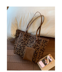 Detail of leopard print tote bag with brown leather handles and matching coin purse charm