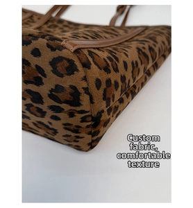 Close-up of leopard print suede texture and brown leather trim on the tote bag
