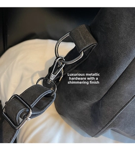 Detail of silver metallic hardware and matte gray suede texture on a tote bag