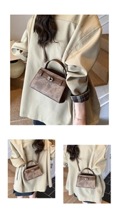 Detailed close-up of a brown textured crossbody bag with a metal twist-lock and top handle