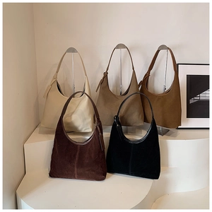 Collection de sacs hobo en daim en cinq couleurs présentés sur des marches blanches