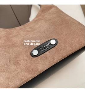 Détail de daim marron mat et cuir noir avec rivets métalliques sur le sac à main