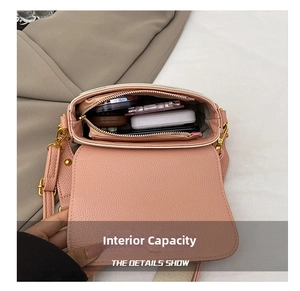 Gros plan sur la grande capacité intérieure et le cuir rose grainé du sac à bandoulière