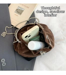 Détails d'un sac seau en daim marron montrant un intérieur spacieux pour mobile et cosmétiques