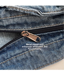 Détail de la fermeture éclair et des coutures marron sur le sac cabas en jean bleu