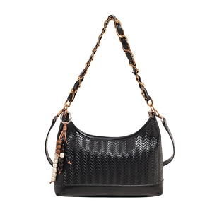 Sac seau tissé noir avec bandoulière chaîne dorée et breloque en perles de bois sur fond blanc