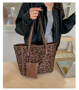 Detailed shot of large leopard print tote bag with small matching pouch in office setting
