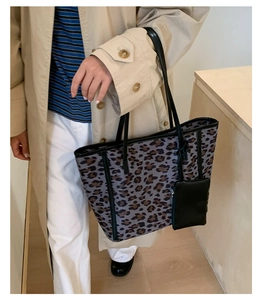 Detail view of large leopard print tote bag with black leather shoulder strap and pouch