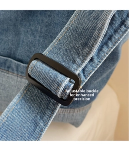 Détail macro d'une bandoulière en denim réglable avec boucle en métal noir mat