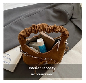 Detail shot of the brown suede crescent bag showing internal storage for phone and cosmetics