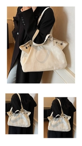 Detail of cream large tote bag with metallic eyelets and wide shoulder strap