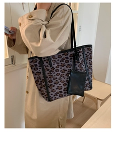 Detail of leopard print tote bag with black accessory pouch and shoulder strap