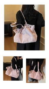 Detailed view of light pink tote bag with vintage texture and silver eyelets on model