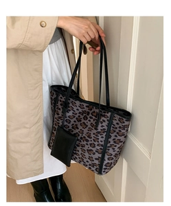 Detail view of leopard print tote bag with black trim and matching small coin purse