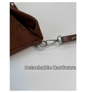 Detaillierte Makroansicht der dunkelbraunen Wildledertasche mit silbernen Metallhaken