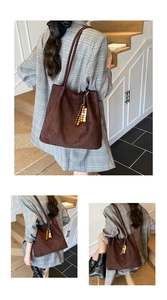 Detail of dark brown suede tote bag with wooden bead fringe tassel and long shoulder strap