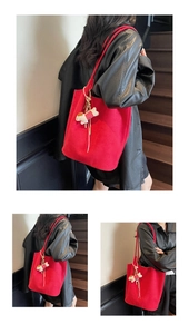 Detail of red oversized tote bag in thick felt with cute white puppy plush charm