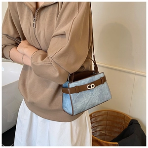 Detail of vintage denim crossbody bag featuring a golden CD metal twist lock closure