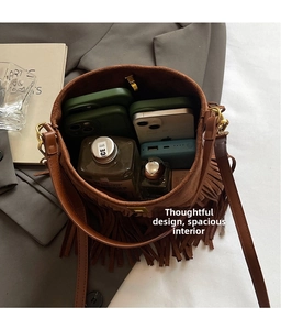 Detail of a brown suede bucket bag showing a spacious interior for everyday essentials