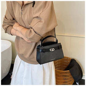Detail of a chic black leather crossbody bag featuring a golden CD metal buckle and lock