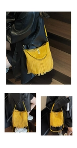 Detail of yellow suede fringe crossbody bag with metallic twist lock and boho tassels