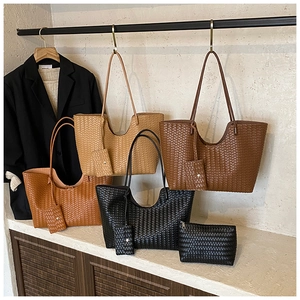 Detail of woven leather tote bag set with matching coin purse and unique U-shaped design