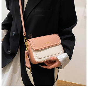 Détail d'un sac bandoulière bicolore avec texture litchi rose et deux lanières
