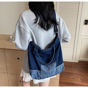 Détail d'un grand sac fourre-tout en jean patchwork avec poche avant et large bandoulière