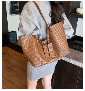 Detail of vintage brown woven leather tote bag with small matching pouch for women