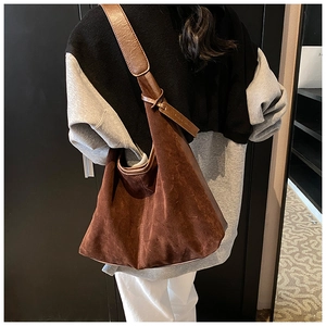 Vue détaillée du sac hobo en daim marron montrant la texture douce et la large bandoulière