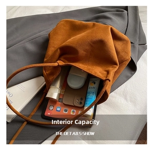Detail showing the large interior capacity of this brown suede tote bag with daily items