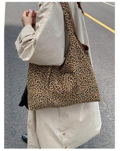 Close-up of leopard print tote bag with thick canvas texture and wide shoulder strap detail