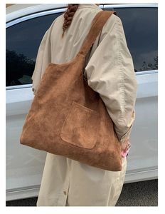 Detail view of large brown suede tote bag with side pocket and leopard print lining