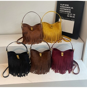 Detail showing five colors of suede bucket bags with long fringes and metal turn-lock closures