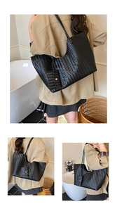 Detail of black woven leather tote bag with matching zipper pouch on shoulder strap