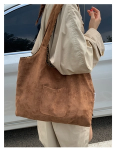 Detail of a brown suede tote bag with leopard print lining and decorative front pocket