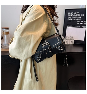 Close-up of black biker shoulder bag featuring silver studs and metallic buckle detail