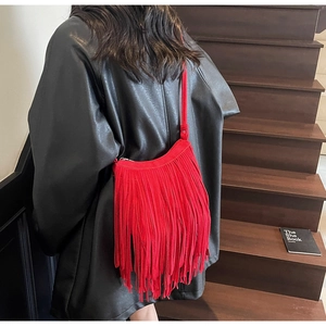 Detail of red tassel shoulder bag with fringe trim on a chic black leather jacket